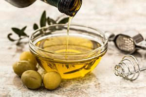 Hair Growth Natural Oils Olive Oil for Scalp Health: A bottle of olive oil with olives, focusing on the scalp health benefits of olive oil.